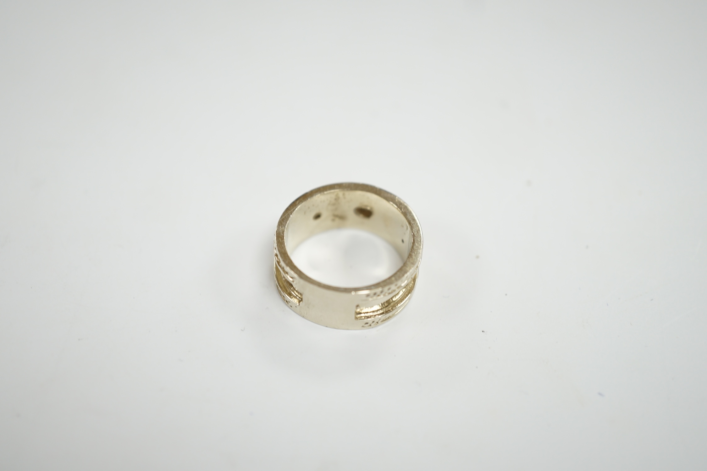 A modern 14k white metal and three stone collet set diamond set band, size M, gross weight 7.5 grams.